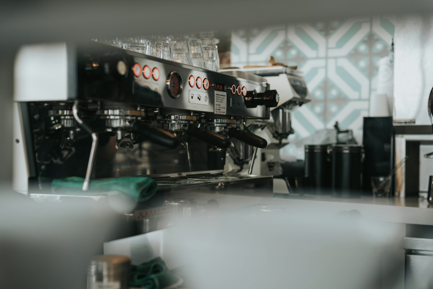 Machine à expresso professionnelle avec boutons éclairés en rouge dans un café.
